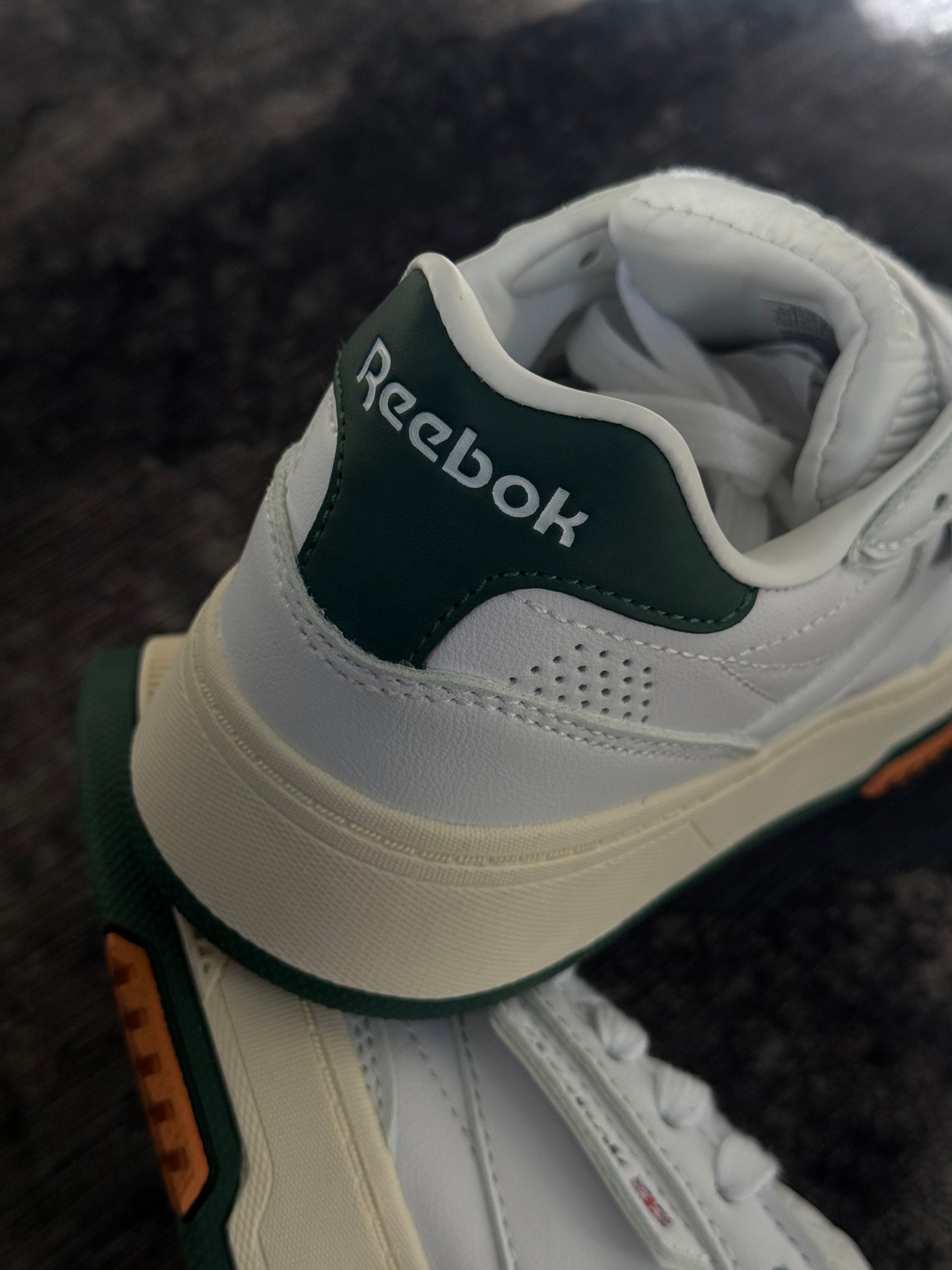 Reebok LTD Club C cuentan con una parte superior de cuero blanco marfil y detalles en verde oscuro en el talón.