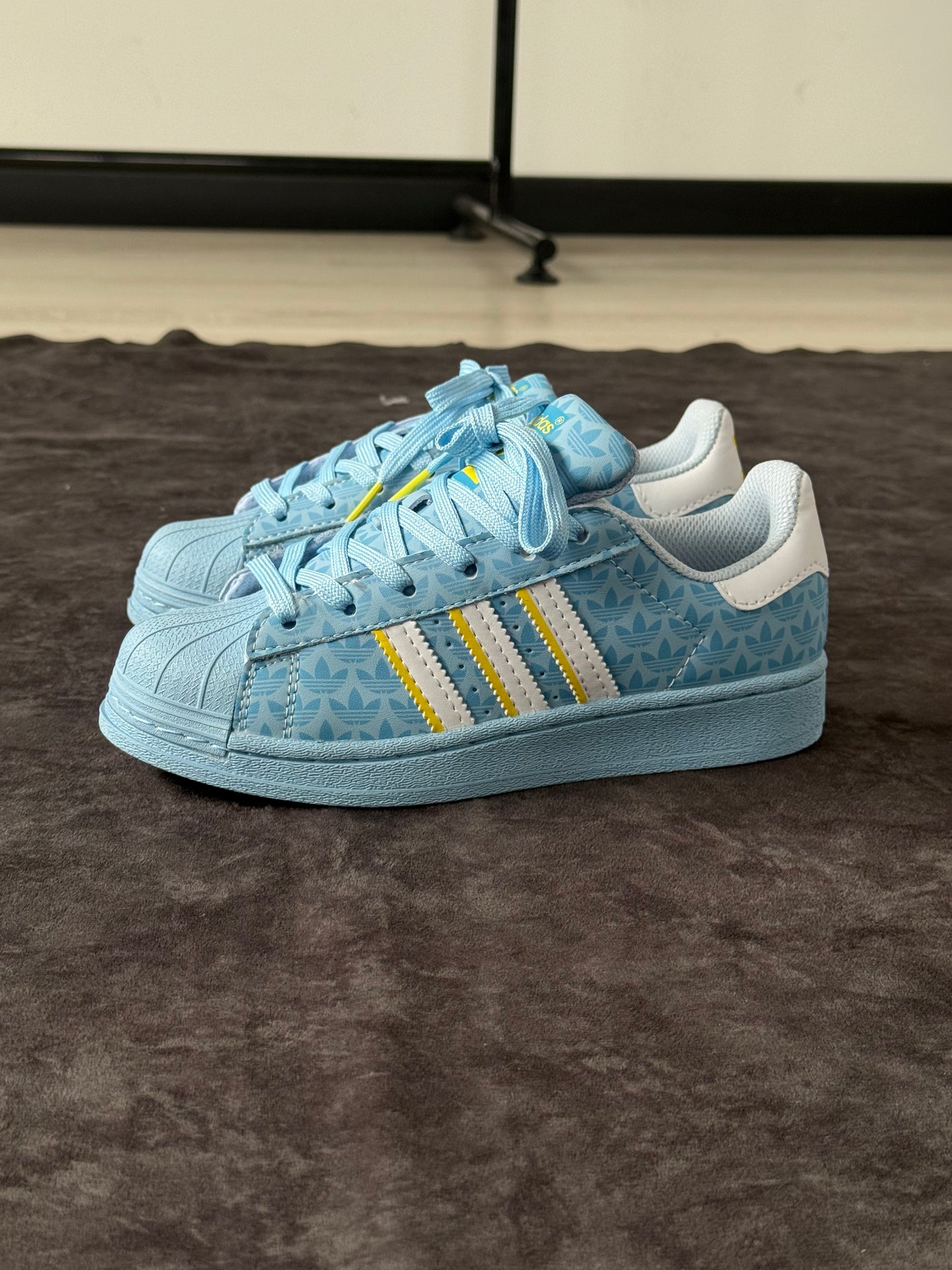 SUPERSTAR ADIDAS ORIGINALS CELESTES CON DETALLES AMARILLOS